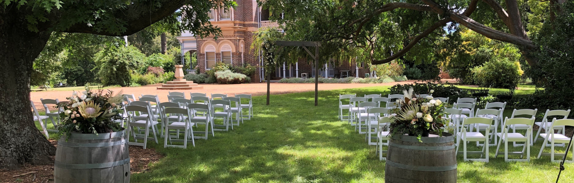 A garden wedding setup with a heritage mansion in the background