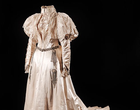 Silk satin wedding gown with intricate detailed 'leg-of-mutton' sleeves. The bodice features a beautiful example of lace and glass bead detailing.
c.1890