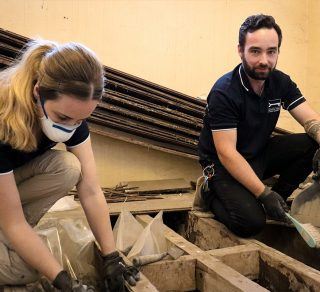 Archaeologists examining artefacts underneath floorboards related image