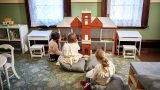 Children play with the dollshouse in the Woodbridge family room