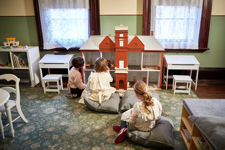 Children play with the dollshouse in the Woodbridge family room