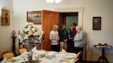 A volunteer shows visitors around the house