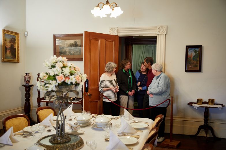 A volunteer shows visitors around the house