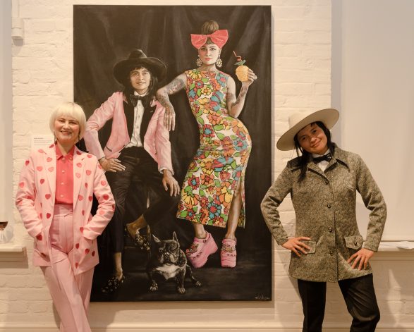 DJ Charlie Villas and her wife Nikita Majajas in front of the painting of them by artist Tania Wursig