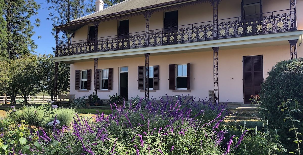 The restored home built and altered by the Pearce Family over many decades looks out onto a formal garden.