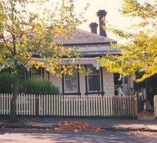 A brick house with wrought iron Verandah lacework related image