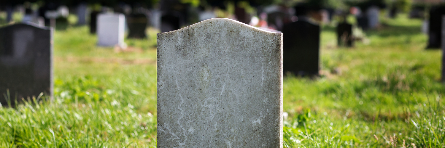 A blank gravestone against a field of green grass.