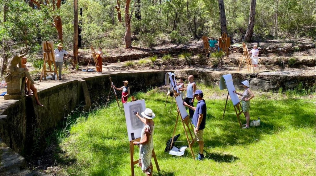 A life-drawing class pictured working on easels.