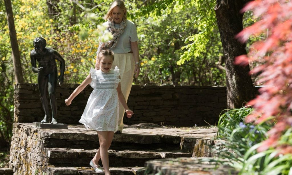A grandmother and granddaughter walk down stairs together at Everglades House & Gardens. 