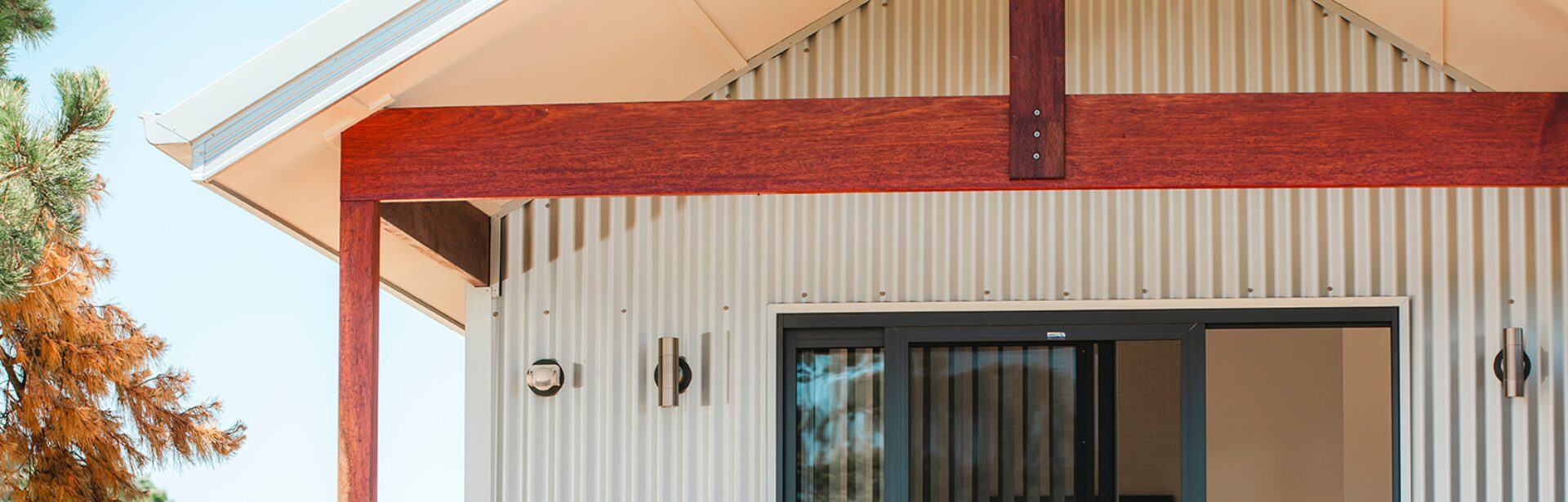 A closeup shot of a new corrugated iron cabin with timber beams supporting the roof