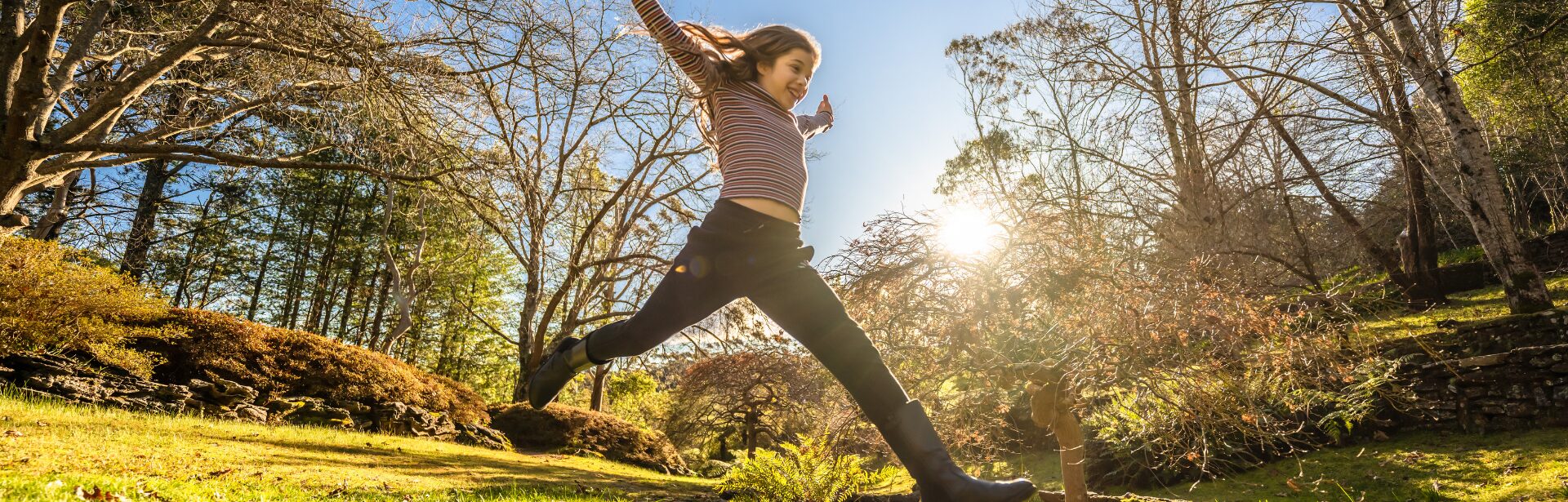 A girl jumping over a creek