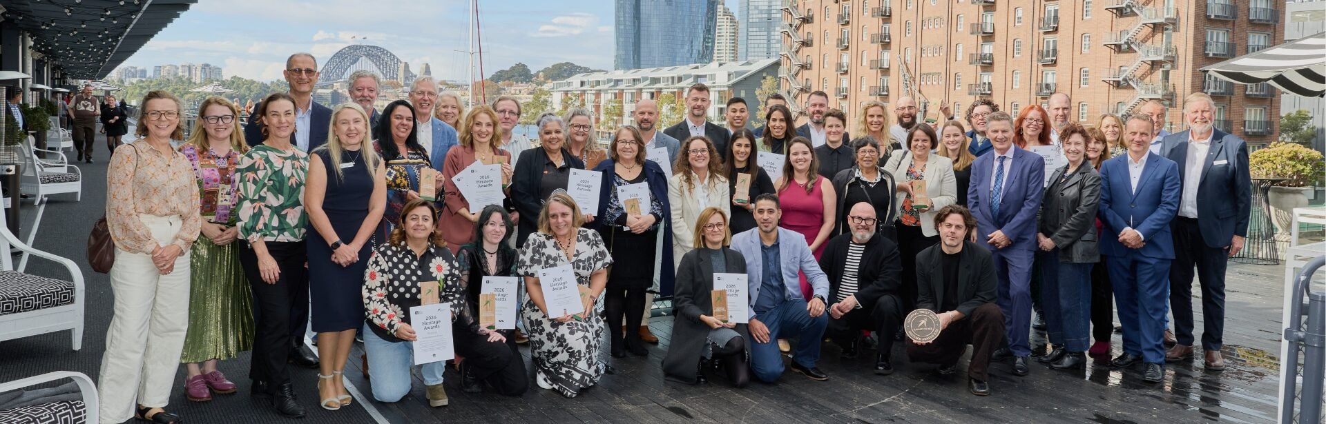 A group of people smiling and holding awards