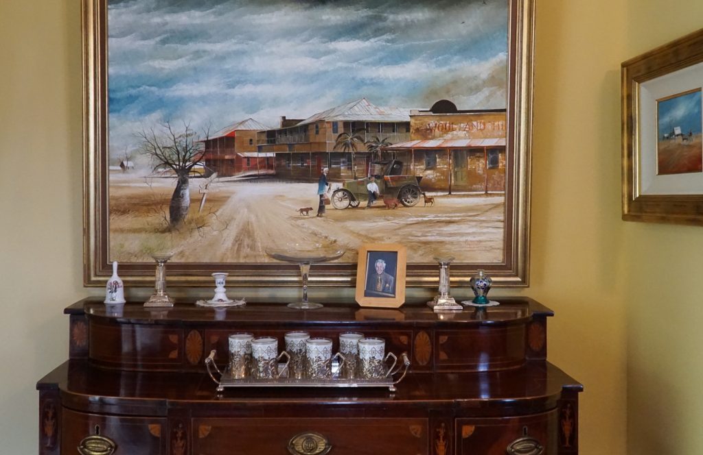 An oil painting hanging over a cabinet at Goldenvale.
