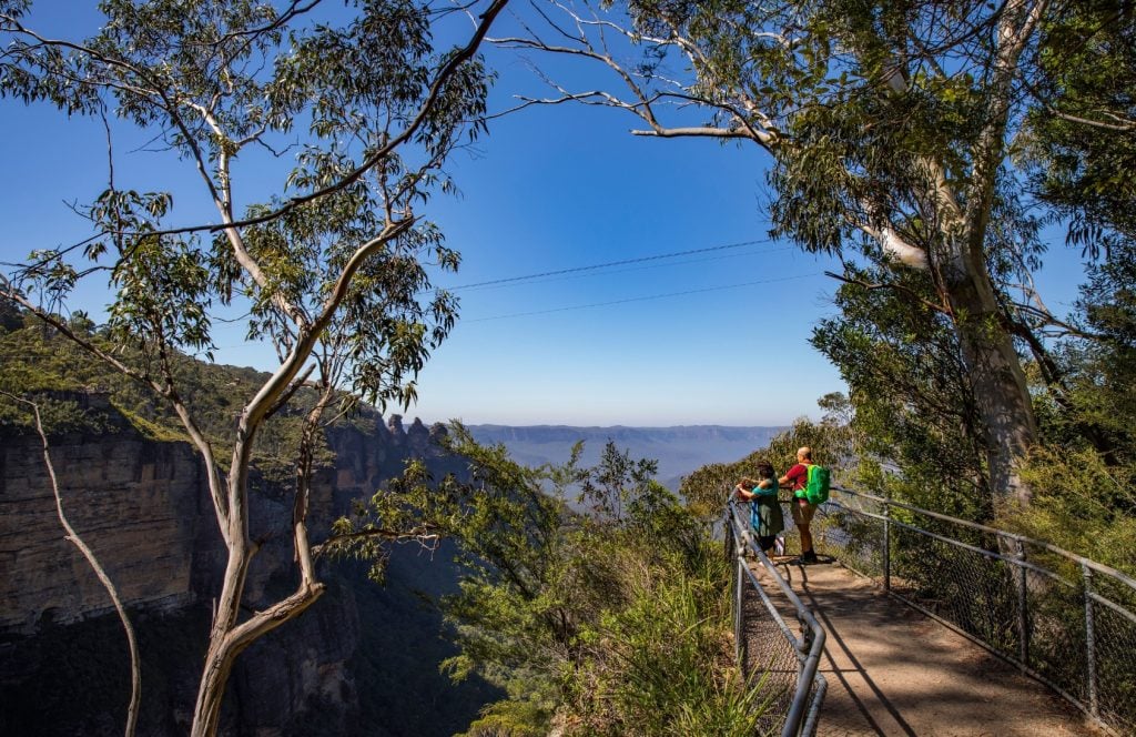 Couple enjoying scenic views across to the Three Sisters from the Furber Steps-Scenic Railway walking track.