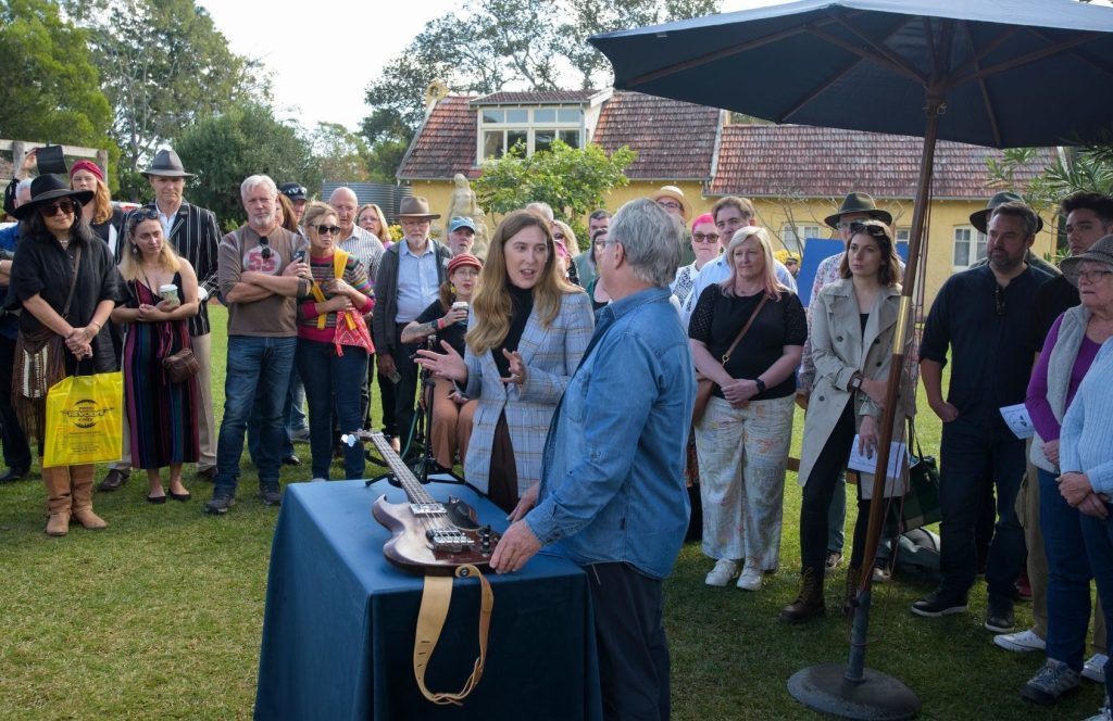 A valuer examines an electric guitar.